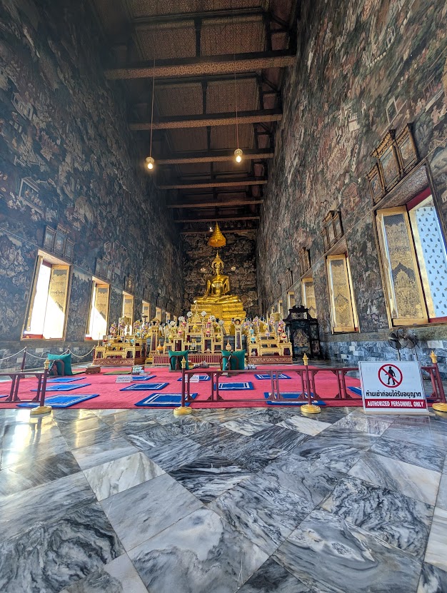 Udsmykket tempelrum med Buddhafigur og vægmalerier i Wat Pho